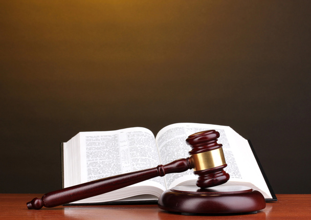 Judge's gavel and open book on wooden table on brown background - Photo, Image