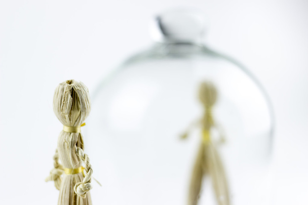 Muñecas de paja de hombre y mujer, separadas por una campana de vidrio
 - Foto, Imagen