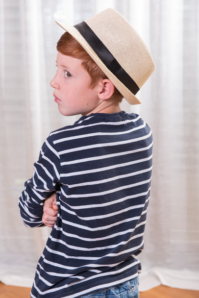 niño con sombrero mirando por encima de su hombro
 - Foto, imagen