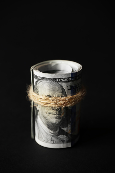 Dollars roll on black background - Foto, Bild