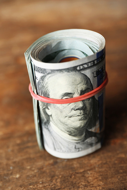 Dollars roll on wooden background - Foto, Imagen