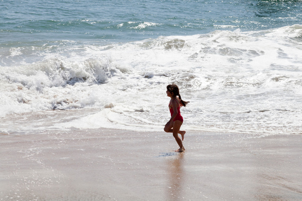 Pieni tyttö juoksi Surf rannalla
 - Valokuva, kuva