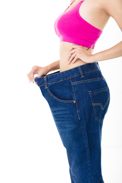 beautiful slim young woman with big jeans - Фото, изображение