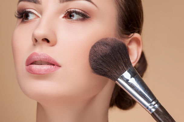 Attractive young woman is getting make-up at salon - Photo, Image