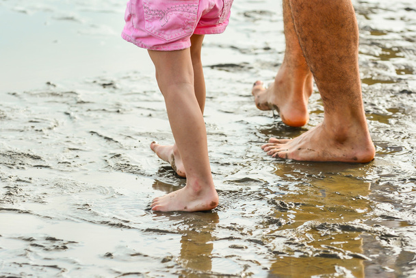 legs of a father and son walking on the beach - Fotoğraf, Görsel