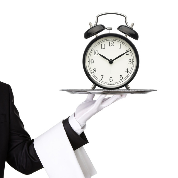 Σερβιτόρος κρατώντας ασημένιο δίσκο με ένα ρολόι - Φωτογραφία, εικόνα