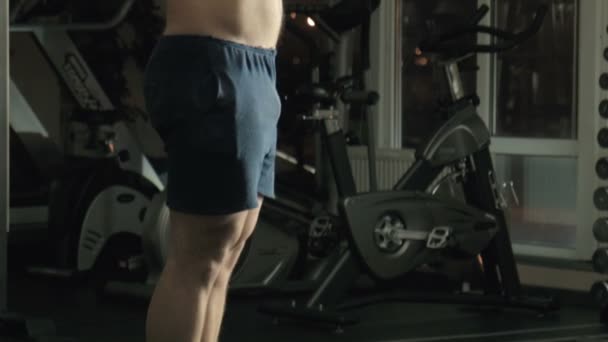 The man the weightlifter lifts a bar in a gym - Video, Çekim