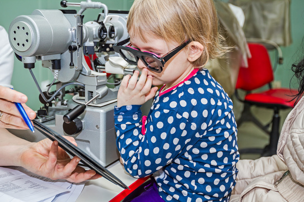 Child is at eye examination in clinic with special equipment. - Φωτογραφία, εικόνα