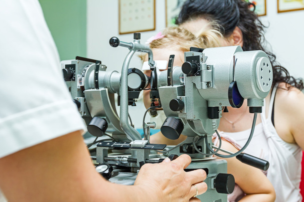 Augenarzt mit Patient, der eine Augenuntersuchung durchführt - Foto, Bild
