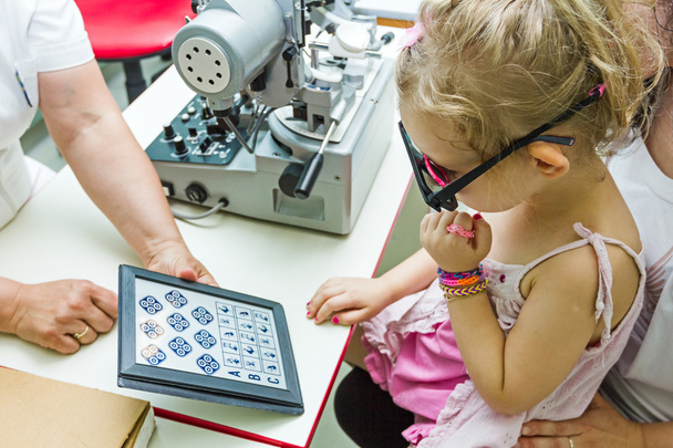 Criança está no exame oftalmológico na clínica com equipamento especial
. - Foto, Imagem