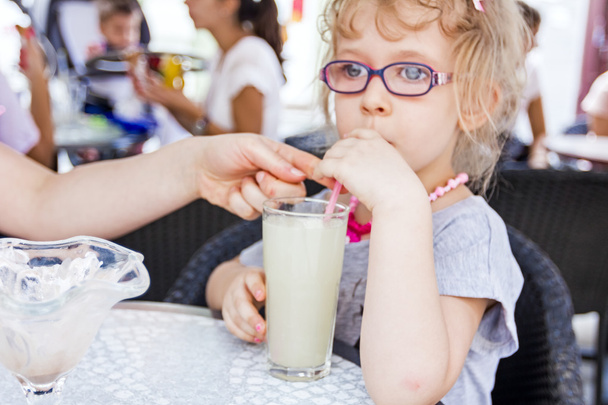 La niña está bebiendo limonada en el restaurante.
. - Foto, imagen