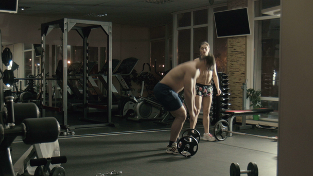 De man de gewichtheffer liften een bar in een sportschool - Video