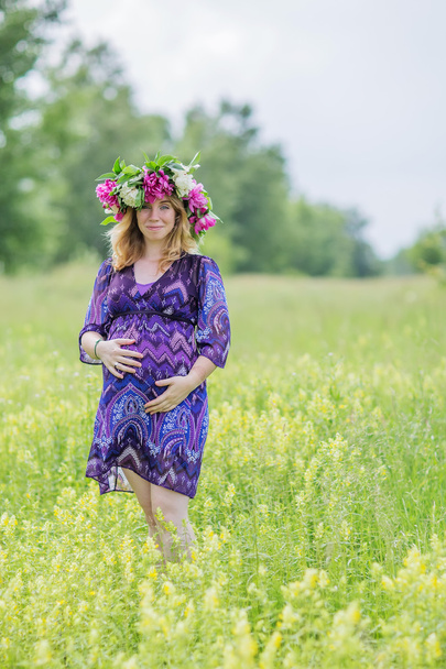 Pregnant lovely woman in sunny summer day - Фото, изображение