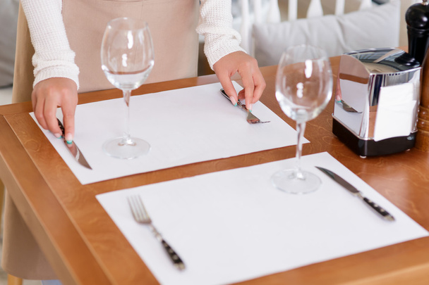 Waitress putting silverware for guests. - Foto, Imagem