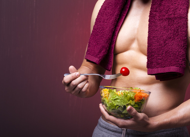 Hombre musculoso sosteniendo un tazón de ensalada
 - Foto, imagen