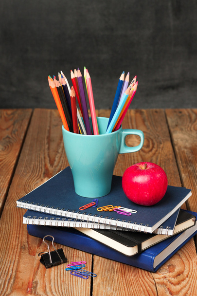 Олівці в кухоль, блокноти та яблуко
 - Фото, зображення