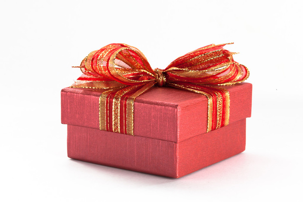 Red gift box with a red ribbon and bow in white isolated - Valokuva, kuva