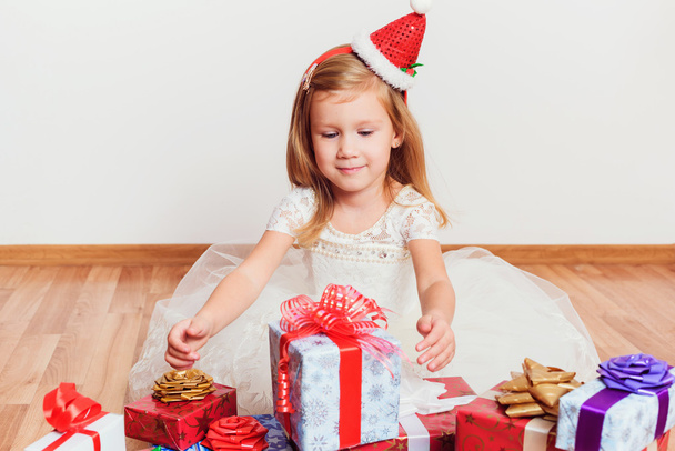 little girl with christmas or birthday presents sitting on the floor - Foto, imagen