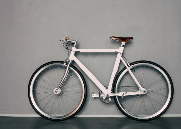 Kiinteä vaihde kaunis vintage polkupyörä seisoo harmaan taustan vieressä
 - Valokuva, kuva