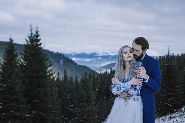 Lovely bride and groom in winter snow on mountain - Photo, Image