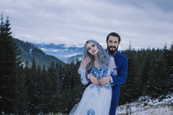 Lovely bride and groom in winter snow on mountain - Foto, Bild
