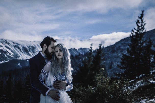 Lovely bride and groom in winter snow on mountain - Photo, Image