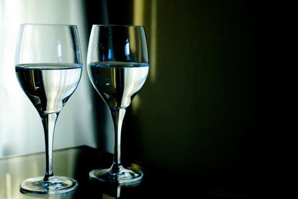 Δύο Κρυστάλλινα ποτήρια νερό γεμάτο με πράσινο φόντο. - Φωτογραφία, εικόνα