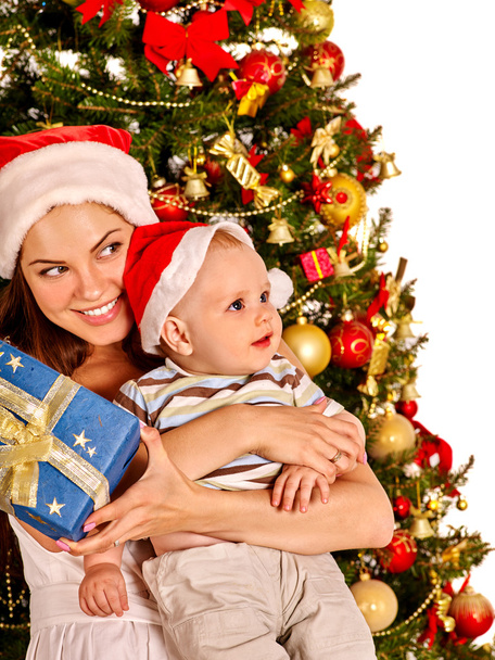 Mom holding baby under Christmas tree - Φωτογραφία, εικόνα