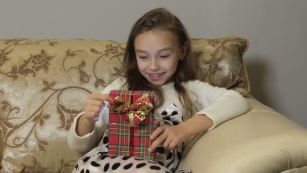 Cute little girl opens a gift box, surprise and joy - Materiał filmowy, wideo