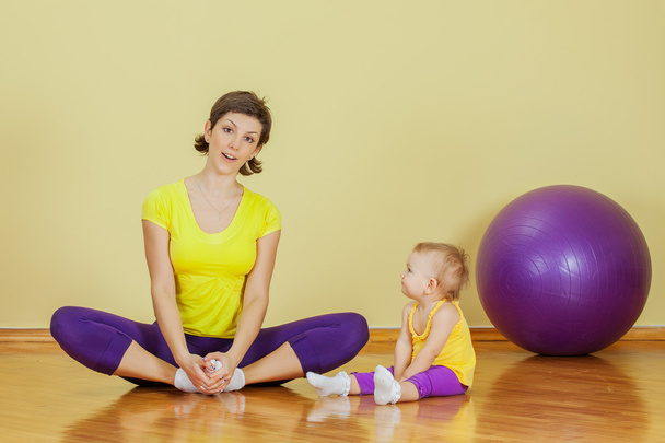 Mother do phisical exercises with her daughter at home - Photo, Image
