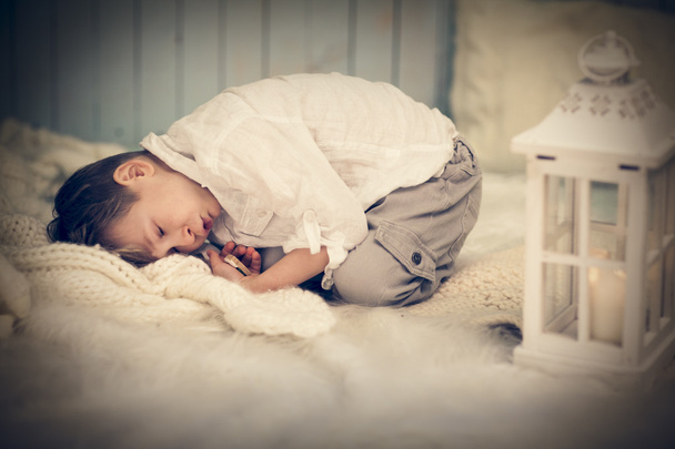 Zrelaksowany ładny dziecko na ciepły wełniany pled w domu - Zdjęcie, obraz