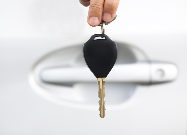 rękę trzymając kluczyk przed drzwi samochodu - Zdjęcie, obraz