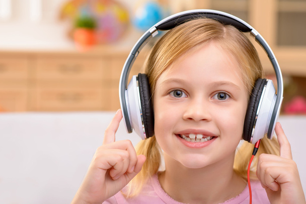 Vivacious little girl listening to music - Фото, изображение