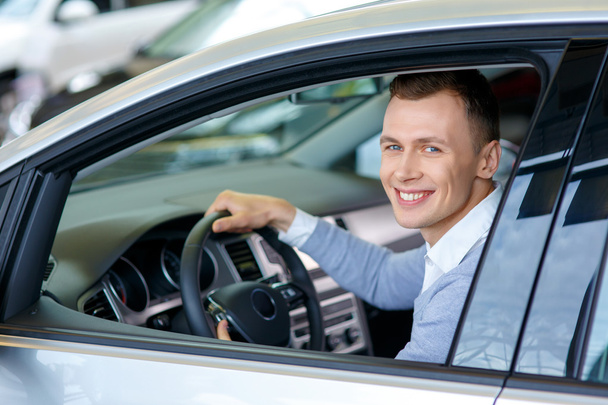 Pleasant man choosing car in auto show - Foto, imagen