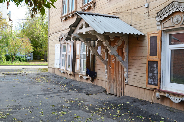 Kaksikerroksinen puutalo kuisti ja ikkunaluukut Irkutsk kadulla
 - Valokuva, kuva