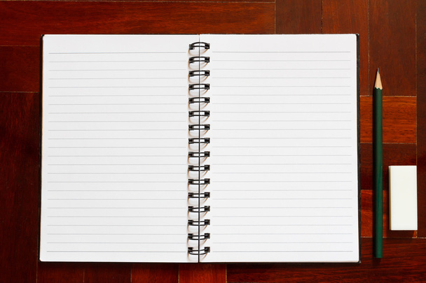 Apri il quaderno con pagina bianca e matita e gomma. Pavimento di legno
 - Foto, immagini