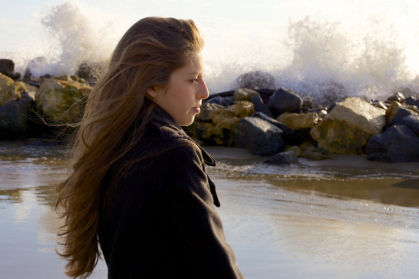 Adolescente donna che pensa di fronte alle onde in inverno sulla spiaggia
 - Foto, immagini