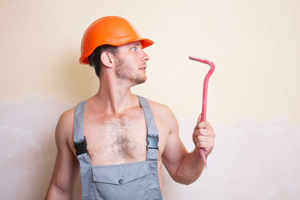 Человек в комбинезоне с инструментом для демонтажа
 - Фото, изображение
