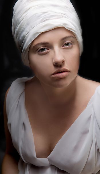 Pregnant woman dressed in a turban and draped in white fabric. - Foto, imagen
