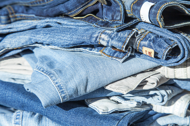 Pile of jeans of various shades on a show-window of shop - Photo, image