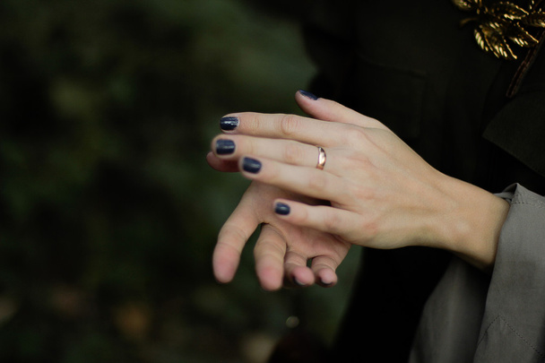 Mains femme avec anneau ongles dorés et bleus
 - Photo, image