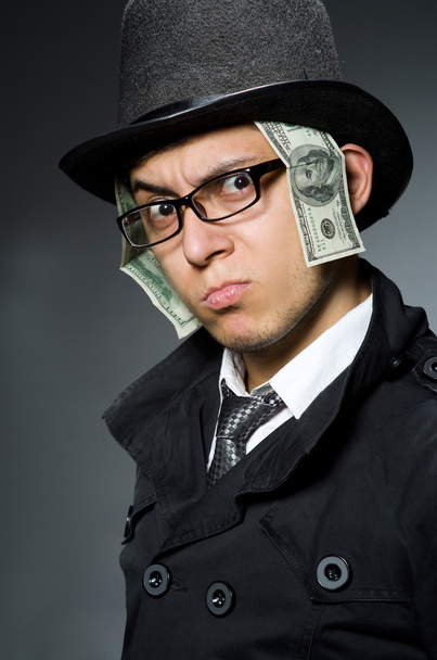 Jovem de casaco preto segurando dinheiro contra cinza
 - Foto, Imagem