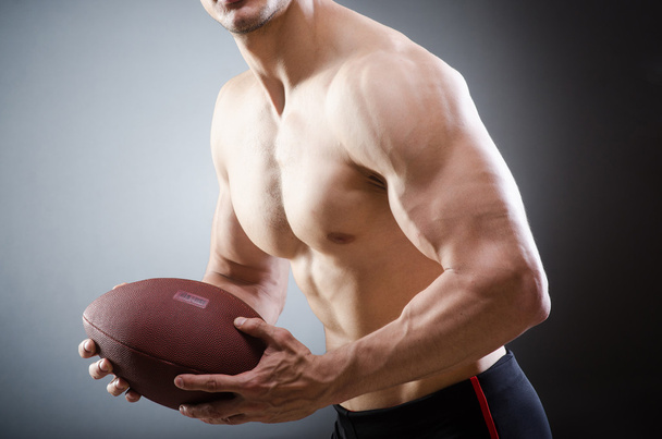 Uomo muscoloso con calcio americano
 - Foto, immagini
