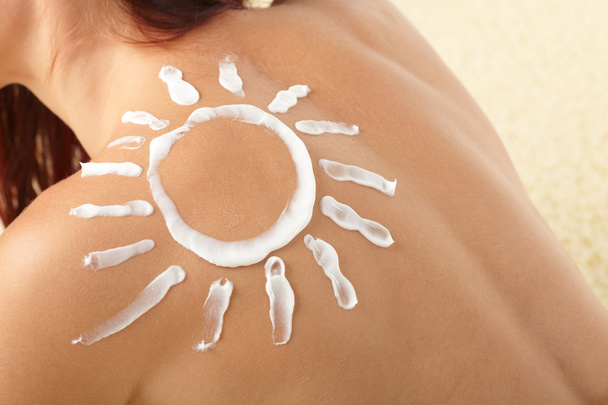 Woman with sun-shaped sun cream - Foto, Imagen