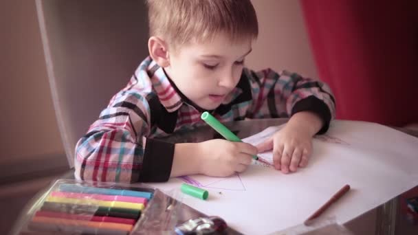 Malý chlapec sedí u stolu a drawing3 - Záběry, video