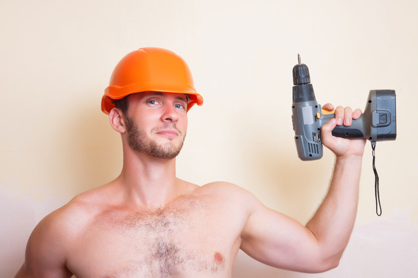 Man in helmet with a screwdriver - Photo, Image