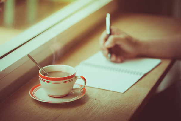 コーヒー カップとノートに書く - 写真・画像