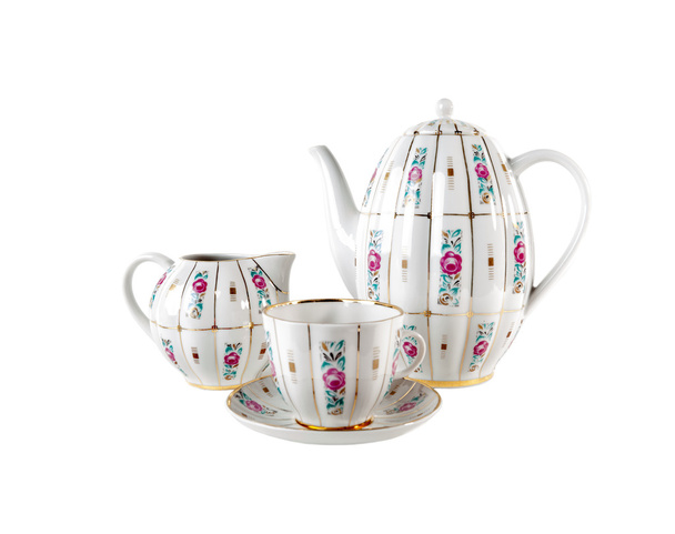 Tetera de porcelana, taza de té y platillo con adorno de rosas florales en estilo retro aislado en blanco
 - Foto, Imagen
