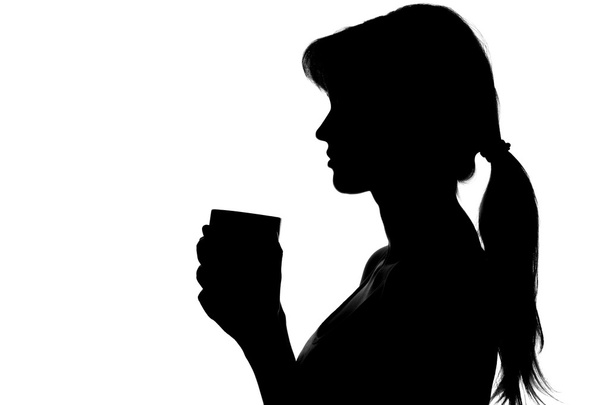 silhouette of a woman with a cup in hands - Fotó, kép