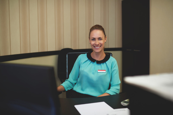 Happy businesswoman sitting at her workplace - Zdjęcie, obraz